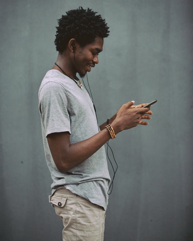 homem negro usando smartphone e sorrindo